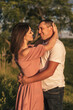 © Tatyana - A couple of lovers man and woman hugging and kissing in a meadow at sunset.Love,passion,youth,happiness,summer concept.