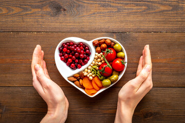 Wall Mural - Hands holding heart shaped dish full of healthy diet food