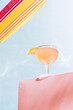 Bottom view of cocktail glass with champagne, martinez drink over blue sunny sky background. Vacation, happiness, summer vibes. Retro style photo