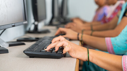 close up shot of group of women hads busy learning or working on computer at training center by typing - concept of empowerment, learning and education