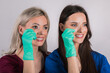 close up young beautiful womans smiling with hand holding dental aligner retainer (invisible) on gray white background for beautiful teeth treatment course concep
