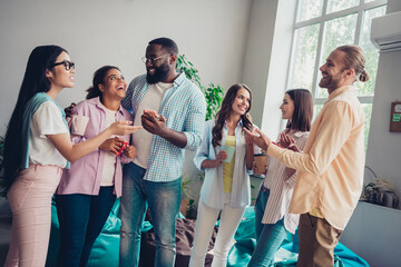 Wall Mural - Photo of funny friendly businesspeople smiling embracing chatting indoors workstation workshop restroom