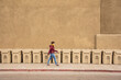 © Tetra Images - USA, New Mexico, Santa Fe, Woman walking past row of garbage bins