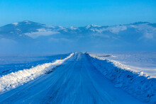 USA, Idaho, Fairfield, Snow Covered Rural Road Leading To Mountains