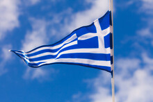 Greek Flag Waving Against Blue Sky