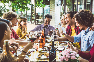 Wall Mural - Happy multiracial family having bbq dinner party outside - Group of friends dining at garden restaurant - Young people enjoying lunch break together - Food and beverage lifestyle concept