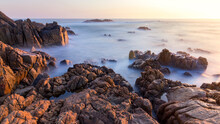 Beautiful Shot Of Stones By The Coastline In The Sunset