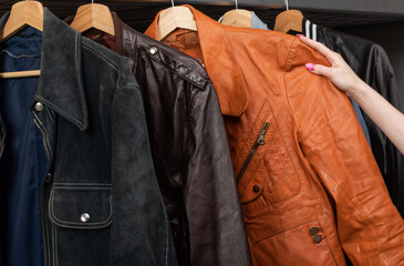 Woman choosing vintage jacket in a used goods store