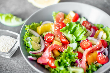 Wall Mural - Salted salmon salad with fresh green lettuce, cucumbers, tomatoes, sweet peppers and red onions on a stone background. Ketogenic, keto or paleo diet lunch bowl.