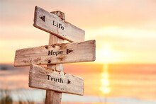 Life Hope Truth Text Quote On Wooden Crossroad Signpost Outdoors On Beach With Pink Pastel Sunset Colors. Romantic Theme.