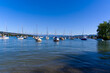 Scenic landscape with moored sailing boats at lakeshore of Lake Zürich at City of Zürich on a sunny summer day. Photo taken June 11th, 2022, Zurich, Switzerland.