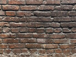 Dark brown aged brick wall. 