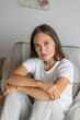 © MyJuly - beautiful European woman is at home in the living room resting. A stylish young adult woman with long hair poses and looks at the camera. a day off or vacation for recreation. peace of mind and mental