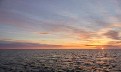 Wall Mural - Baltic sea at sunset. Dramatic sky, blue and pink glowing clouds, soft golden sunlight, midnight sun. Picturesque dreamlike seascape, cloudscape, nature. Panoramic view