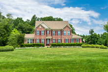 Large Traditional Red Brick Colonial House On A Green Lawn In Virginia.