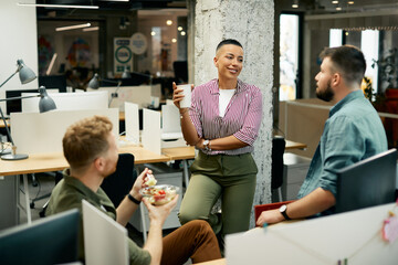 Group of young coworkers enjoy in conversation during break in the office.