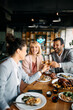 © Drazen - Cheerful colleagues toasting with wine while having business lunch in restaurant.
