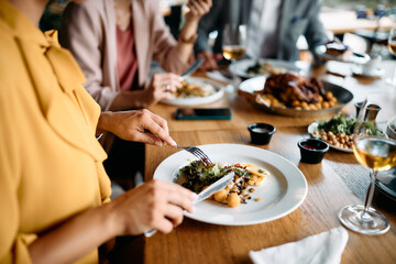 Close up of entrepreneur having business lunch with her coworkers in restaurant.