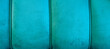 Turkusowe aksamitne tło. Zdjęcie panoramiczne turkusowego obicia, widoczne przeszycia, miękki i puchaty materiał, miejsce na tekst.
