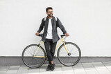 Young handsome man with bike over white wall background in a city, Smiling student man with bicycle smiling outdoor, Modern healthy lifestyle, travel, casual business concept