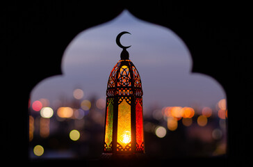 Wall Mural - Lantern that have moon symbol on top with blurred focus of paper cut for mosque shape background. Ramadan Kareem and Islamic new year concept.