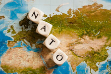 NATO Spelled With Dice On A World Map, Concept For The North Atlantic Treaty Organization Expanding Its Members