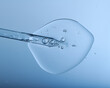 Pipette with bubbles and clear formulation being expelled. Clear liquid with bubbles resembling glycerin, hyaluronic acid or keratin in laboratory or scientific setting. 