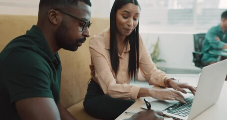 Poster - Two young business people sitting in the office together and having a discussion while using a laptop. Young latina businesswoman talking to her african american colleague while using a wireless