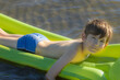 Boy is sleeping on an inflatable mattress in the water. The child alone in the water. A young man smiles while sleeping in the water. Soft selective focus