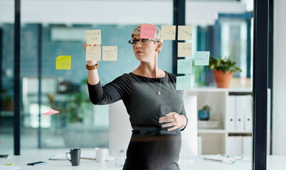 Poster - Getting a few ideas rolling for a new project. Shot of a pregnant businesswoman brainstorming with notes on a glass wall in an office.