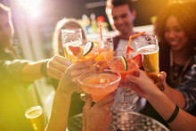 Ringing in the weekend. Shot of a group of people toasting with their drinks at a nightclub.