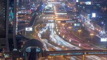 Busy Sheikh Zayed Road Aerial Night Timelapse, Metro Railway And Modern Skyscrapers Around In Luxury Dubai City.