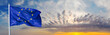 Flag of the European Union waving in the wind on flagpole against background of the sunrise, banner, close-up