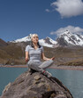 Mujer Latina en pose de Yoga en las montañas realizando una sesión de meditación.