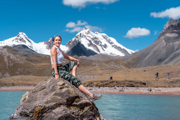 Blond woman sitting on a stone in the snowy Ausangate, by Yuri Ugarte Cespedes.