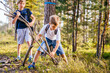 Two boys playing in a forest. Children collecting firewood in summer wood. Vacation, lifestyle, outdoor activities for kids.