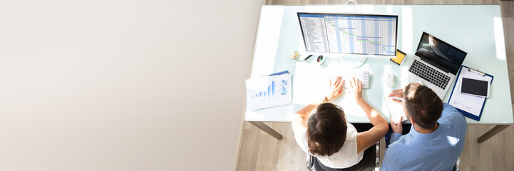 Poster - Two Businesspeople Analyzing Gantt Chart On Computer