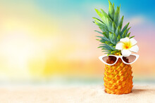 Pineapple With Sunglasses On Tropical Beach Background. Summer Beach Concept.