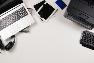 Wall Mural - Top view to old laptop computers, digital tablets, mobile phones, printer, many used electronic gadgets devices on white background. Planned obsolescence, electronic waste for recycling concept