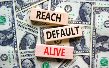 Reach default alive symbol. Concept words Reach default alive on wooden blocks on a beautiful background from dollar bills. Business, finacial and reach default alive concept.