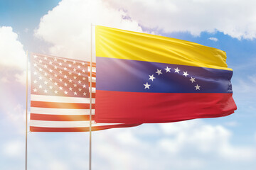 Sunny blue sky and flags of venezuela and usa