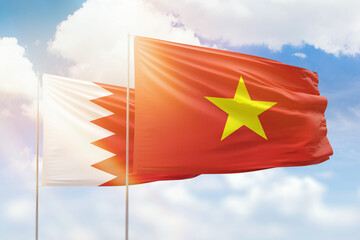 Sunny blue sky and flags of vietnam and bahrain