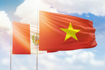 Sunny blue sky and flags of vietnam and peru