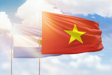 Sunny blue sky and flags of vietnam and argentina