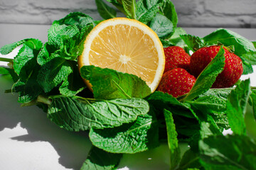 Wall Mural - Lemon, mint, strawberry on a light background