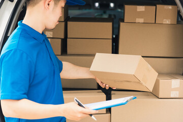 Wall Mural - Asian young delivery man courier in uniform hold documents clipboard checking list parcel post boxes near a car for service shipment to customer, Online shopping service concepts