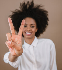 Smiling Latin woman making two countdown times sign gesture with hand fingers on pastel background.