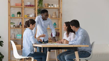 Wall Mural - African and diverse staff discuss task at briefing in office, employees talking, joking, have fun, laughing take part in group meeting in boardroom. Teamwork, cooperation of friendly workmates concept