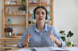 © fizkes - Attractive businesswoman sit at desk in office look at camera make speech, talk to client on videocall, take part in on-line business training or meeting, teacher lead class use video call app concept