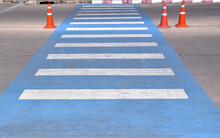 Blue White Pedestrian Crossing And Three Traffic Cone On Concrete Road